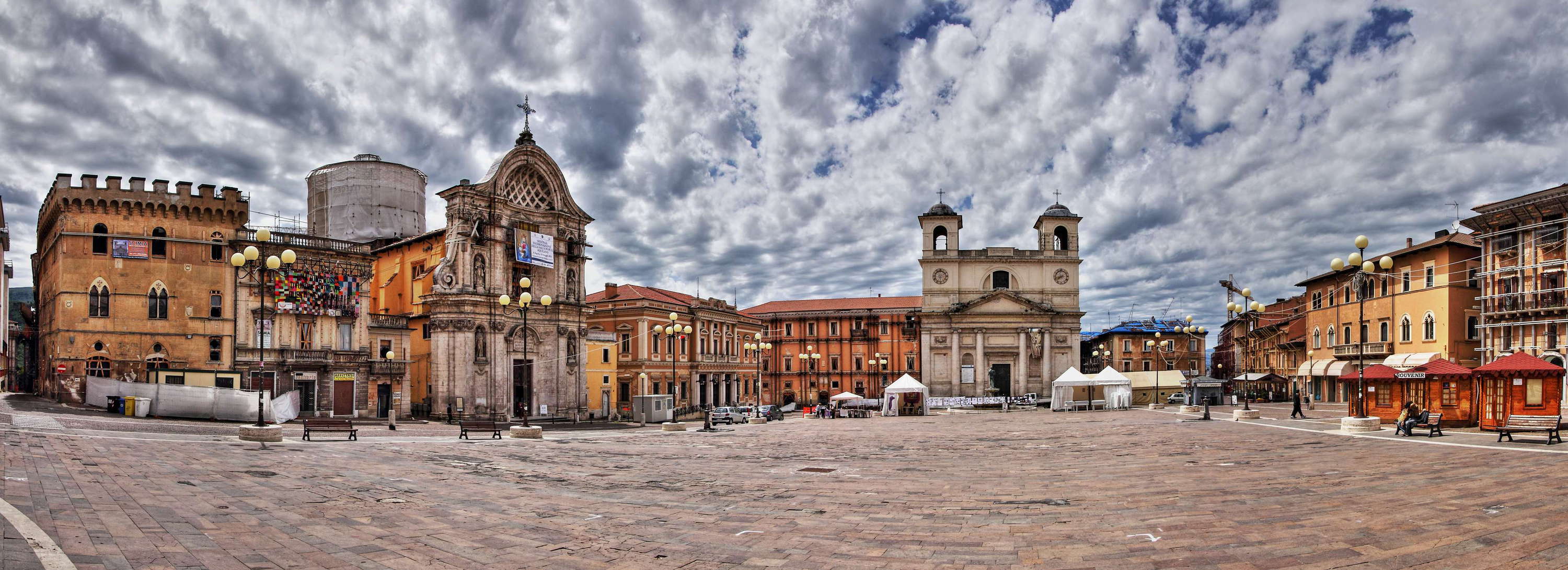 This image was created more than four years after the catastrophic earthquake of 6 April 2009. The historic centre still has the character of a ghost town, even though some cafés and hotels have reopened. Most buildings have been temporarily reinforced. The main square, once a bustling market place and one of the social and cultural foci of the city, is almost void of people. WI_e2108_031_002.jpg