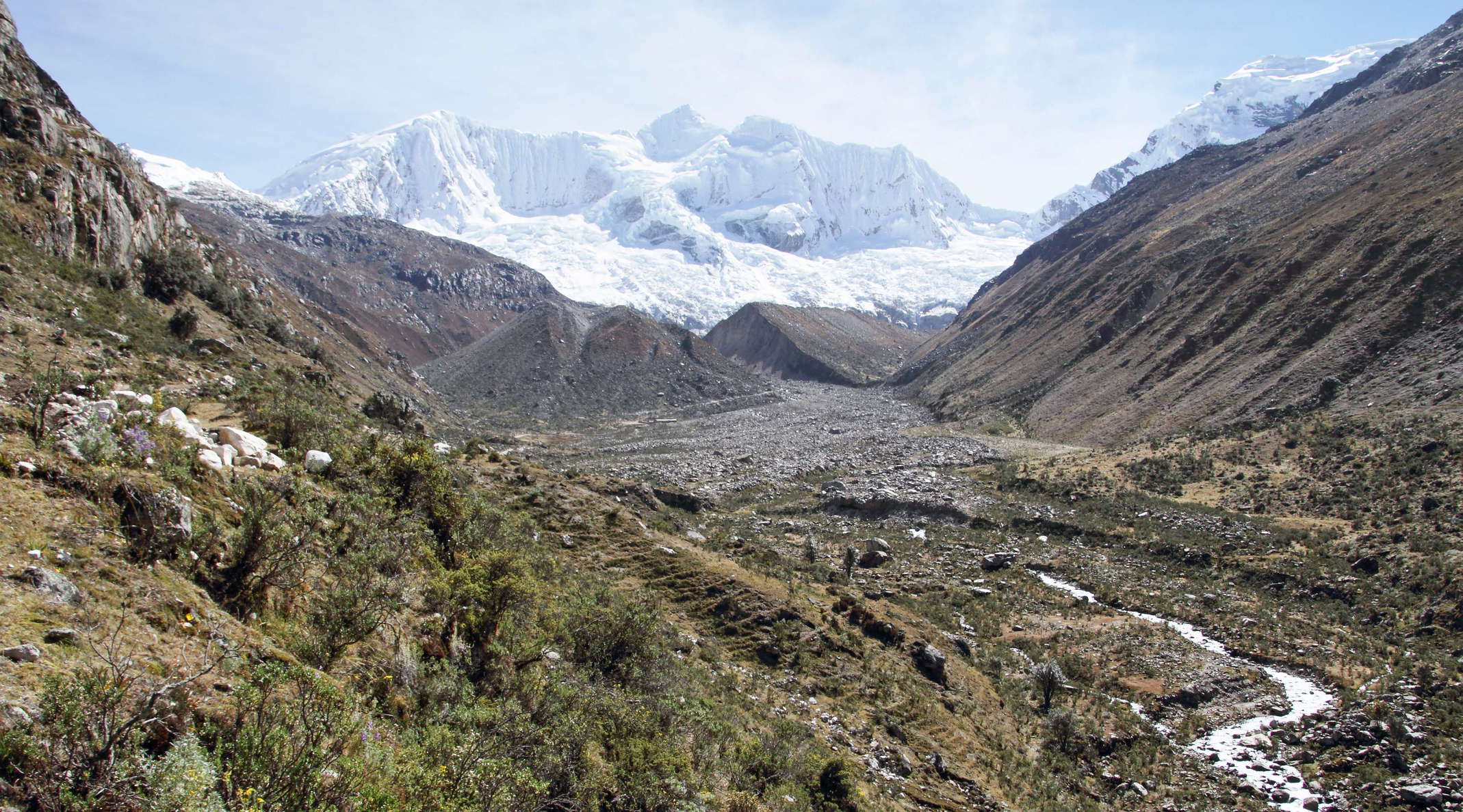 The prominent gap in the moraine ridge in the centre of this image and the debris deposited directly downstream are the results of a dam failure and sudden drainage of Laguna Palcacocha (formerly impounded behind this ridge) on 13 December 1941. The resulting mass flow caused major damage and numerous fatalities 23 km downstream in Huaraz. The summit in the central background of the image is Nevado Palcaraju (6274 m). WI_pe051.jpg