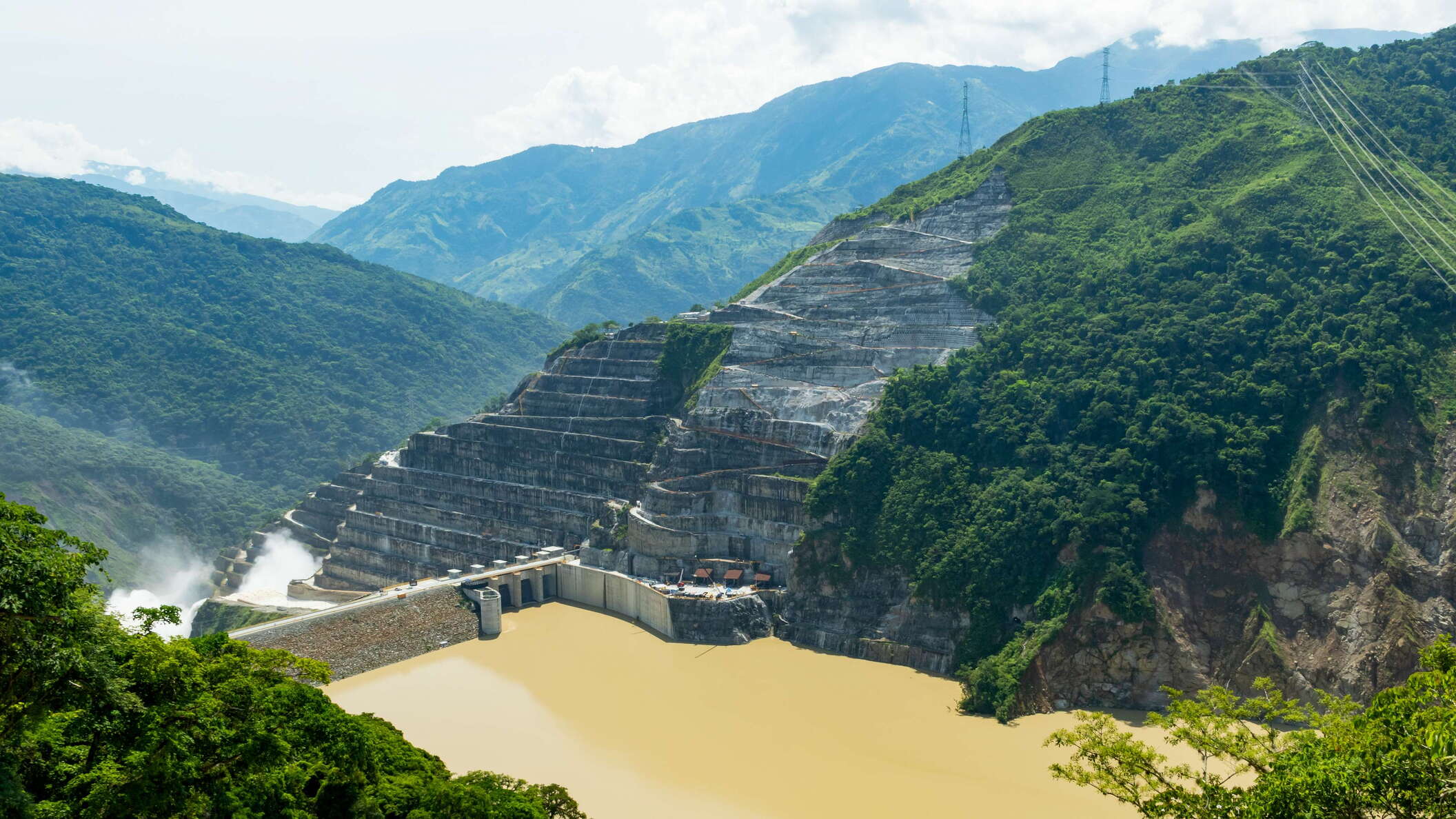 This 225 m high embankment dam on the Cauca River is part of a hydropower project under construction. Operation should have started in late 2018, but a landslide earlier the same year (right side of the image) blocked the diversion tunnel. As an emergency measure, the water was led through the power house. The dam was completed rapidly, so that the spillway (seen on the left side of the scene) takes all the runoff at the time of the photo, until the start of operation of the power plant. WI_co215.jpg