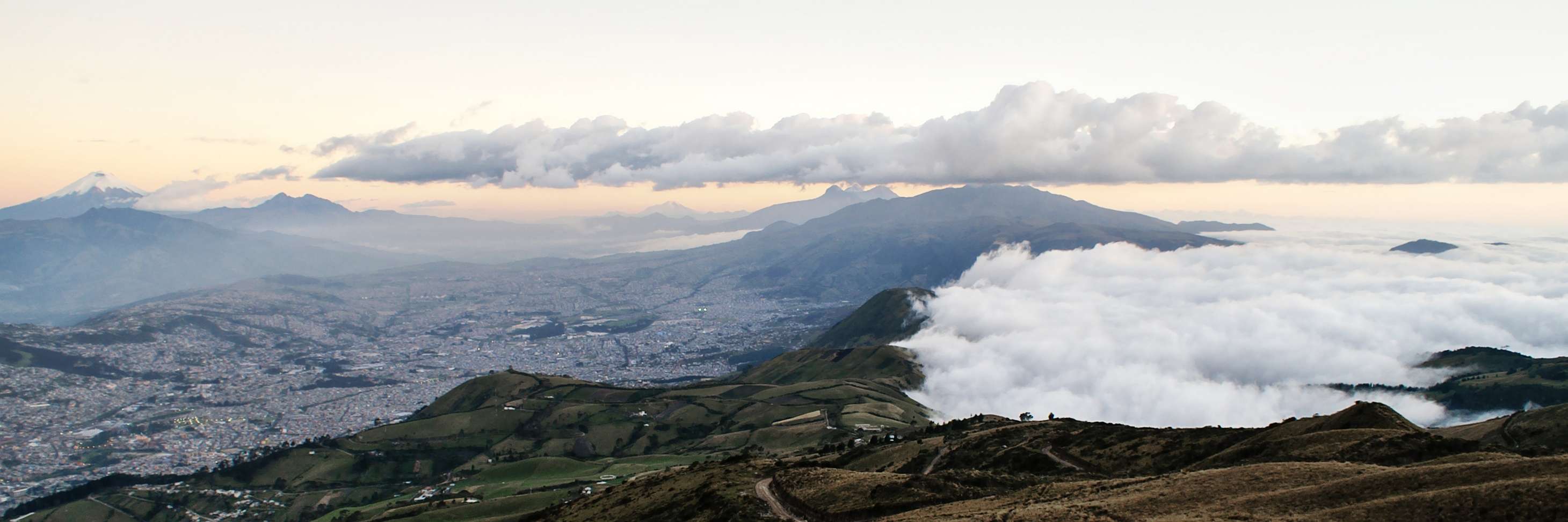 Late afternoon view from Cruz Loma towards S. The Eastern Cordillera (Volcán Cotopaxi, 5897 m) is seen on the very left side, Quito in the left centre centre and the Western Cordillera in the right portion of the image. Volcán Chimborazo (6268 m) is seen in the very distant central background. This photograph was taken during a foehn situation with winds coming from the Pacific side. WI_ec240.jpg